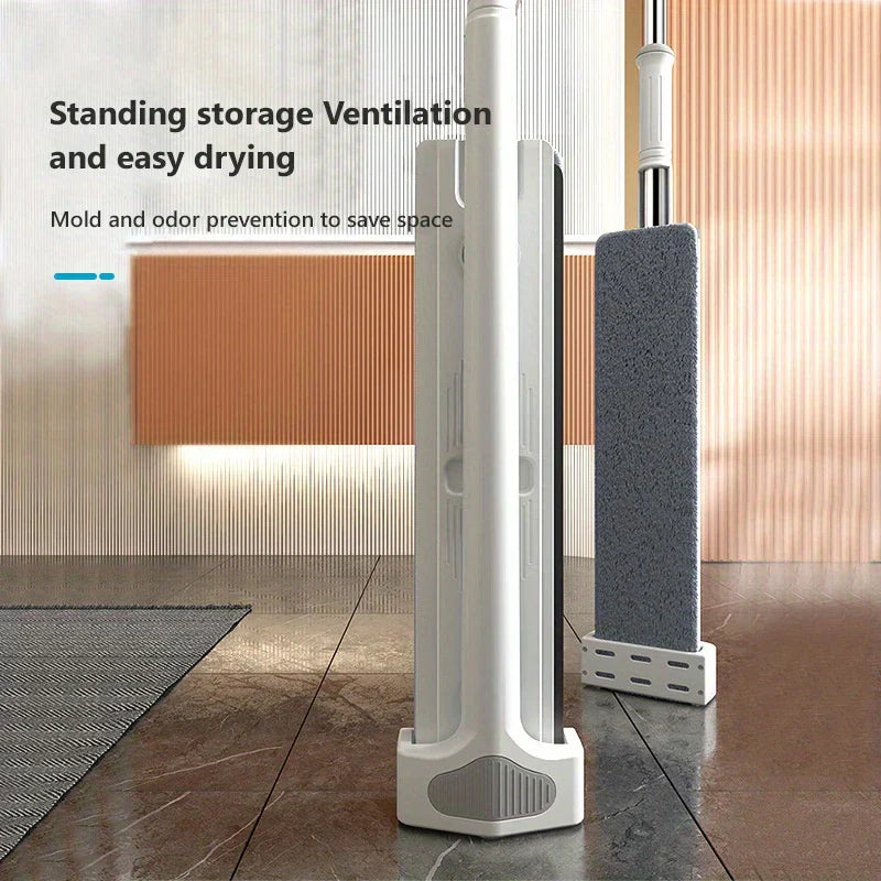 Mop And Bucket System - Flat mop standing upright for storage, with replacement mop head on stand nearby, on tiled floor