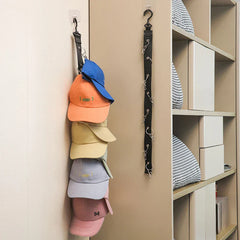 Hat Organizer - Strap holding stacked baseball caps mounted on a wall next to an empty matching strap beside a shelving unit
