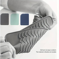 Estuche de silicona resistente al calor para rizador - Manos doblan una alfombrilla de silicona para mostrar su flexibilidad, con tres muestras de color