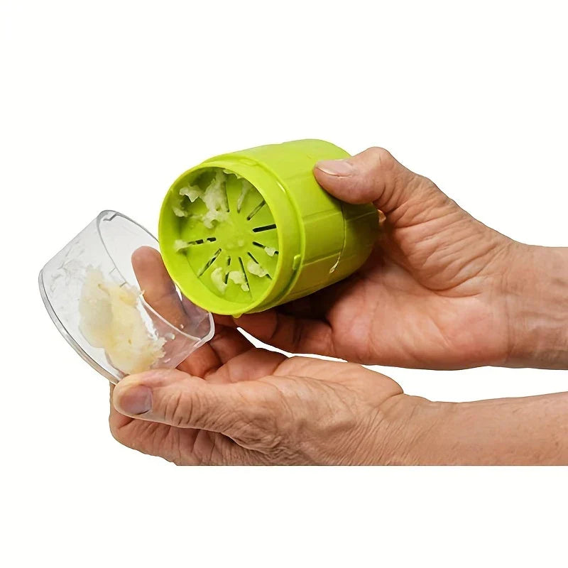 Garlic Press Mincer - Hands twisting a manual garlic crusher, with minced garlic collected in its clear base container