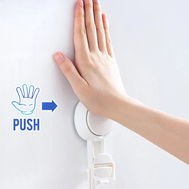 Suction Cup Hook - Hand pressing a push-marked suction hook against a smooth wall to adhere it.