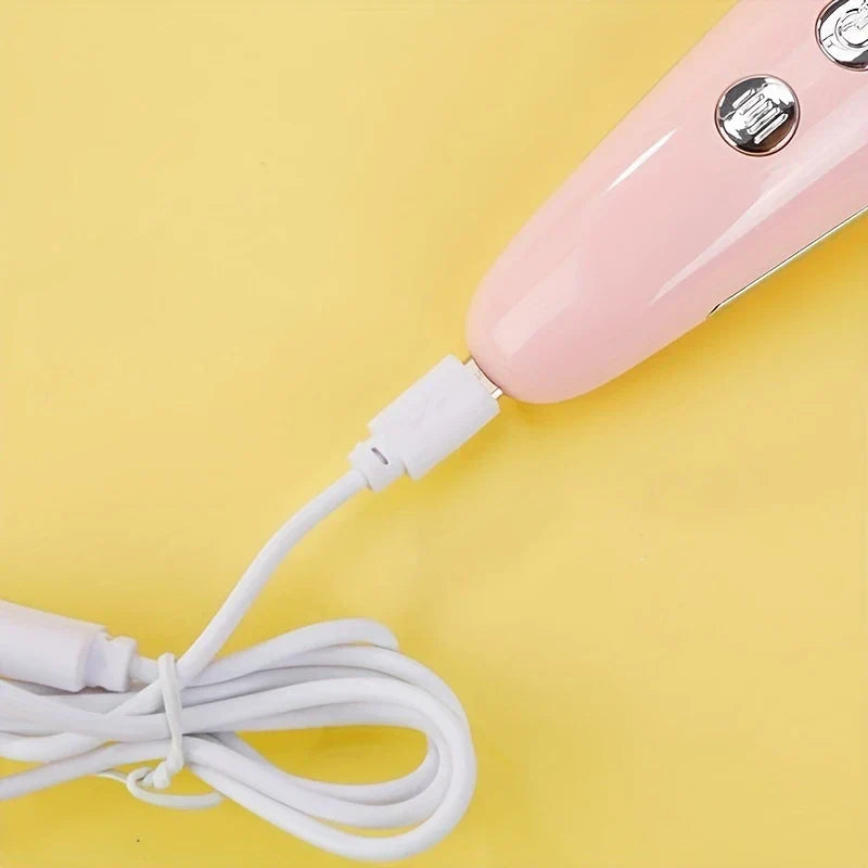 High Frequency Facial Wand - Close-up of a pink handheld device with a white charging cable plugged into its port on a yellow surface
