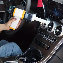 Car Vacuum Cleaner - Hand holding vacuum with brush attachment cleaning a car dashboard air vent
