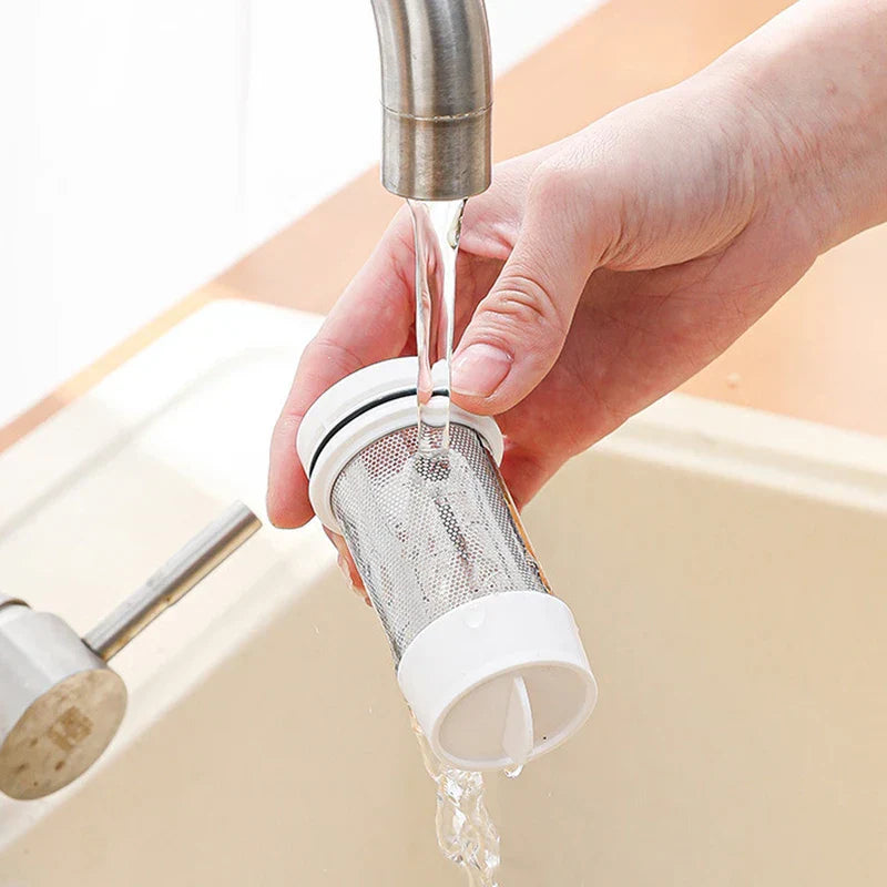 High Power Vacuum - A hand rinses a small mesh filter under running tap water over a sink.