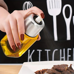 Oil Mister Sprayer - Hand pressing the spray nozzle to dispense a fine mist of oil over cooked food on a plate