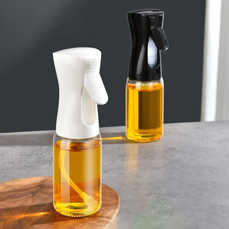 Mister Bottle - Two oil sprayers with white and black trigger tops, filled with cooking oil, placed on a kitchen countertop