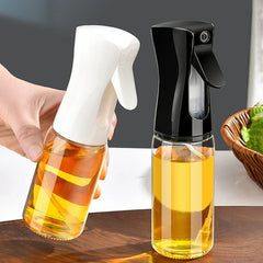 Mister Bottle - Two glass spray bottles with white and black trigger tops, filled with golden liquid, one held by a hand.