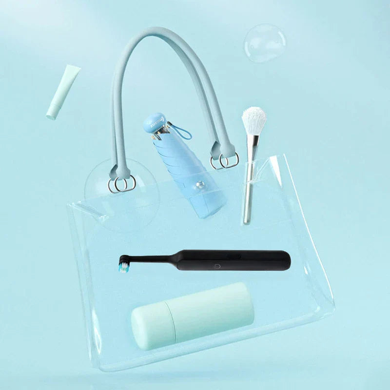 Cepillo de dientes eléctrico recargable - Cepillo de dientes eléctrico negro colocado dentro de una bolsa de mano de plástico transparente con otros artículos de cuidado personal