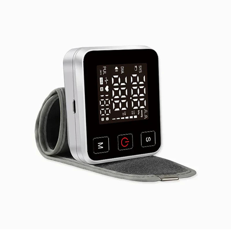 Bp Checker Machine - Side angle view of silver-cased wrist-worn blood pressure monitor with attached cuff laid flat