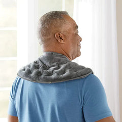 Hot Cold Therapy Neck Wrap - Person wearing a gray quilted neck and shoulder wrap while standing near a window