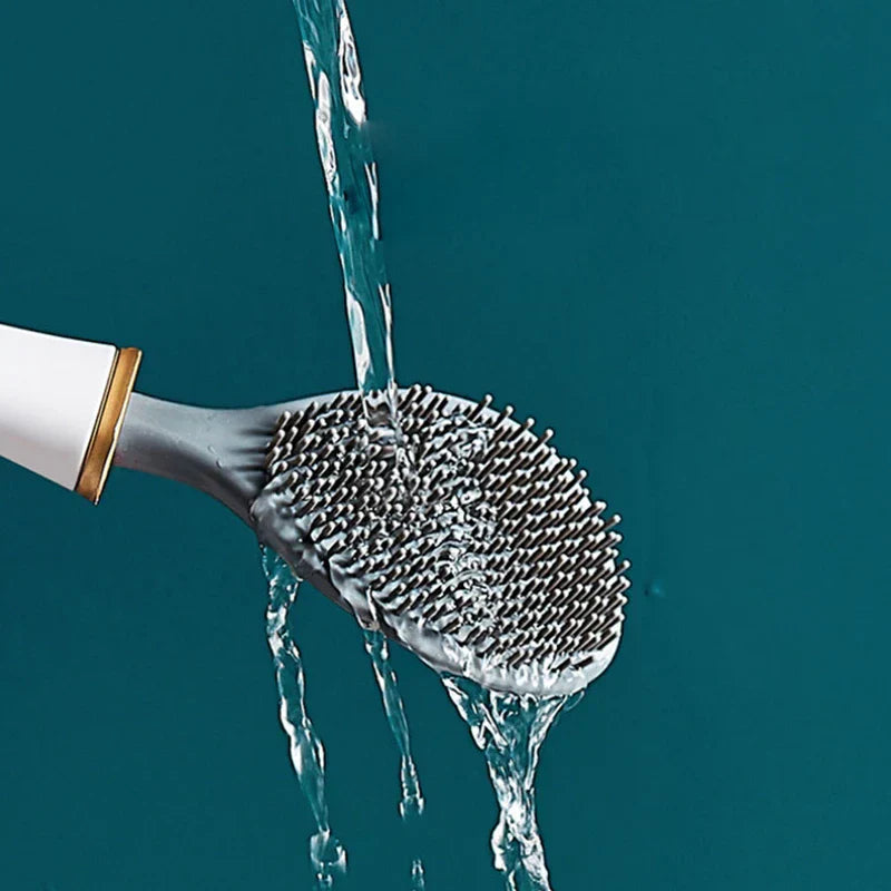 Close-up of a scrubber brush head with water pouring over it, featuring dense bristles.