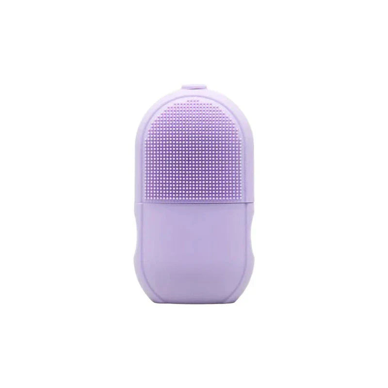 Facial Massager - Light purple silicone skincare device with raised bristle cleansing surface on upper half, smooth ergonomic grip on lower half
