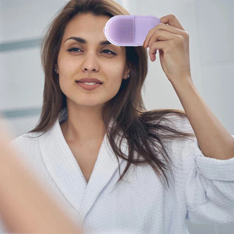 Facial Massager - Woman in white bathrobe holding a closed purple facial ice roller near her forehead