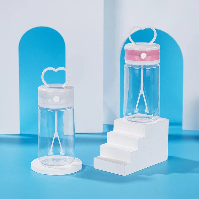 Insulated Coffee Travel Mug - Two clear plastic water bottles with heart handles—one white cap on round stand, one pink-banded cap on stepped white stand against blue and white background.
