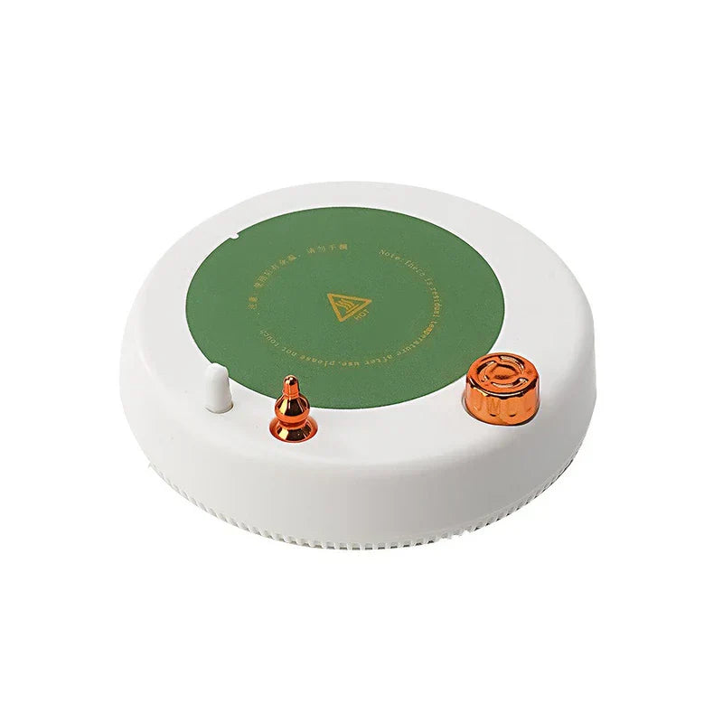 Insulated Mug - White circular warming and stirring base with green heating surface, copper control knob, copper magnetic stirrer, white alignment peg, and hot surface warning marking