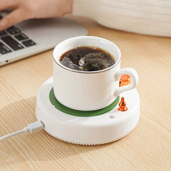 isolierter becher - Weiße Keramiktasse mit schwarzem Kaffee auf der angeschlossenen USB-betriebenen Basis, auf einem hellen Holztisch neben einem Laptop