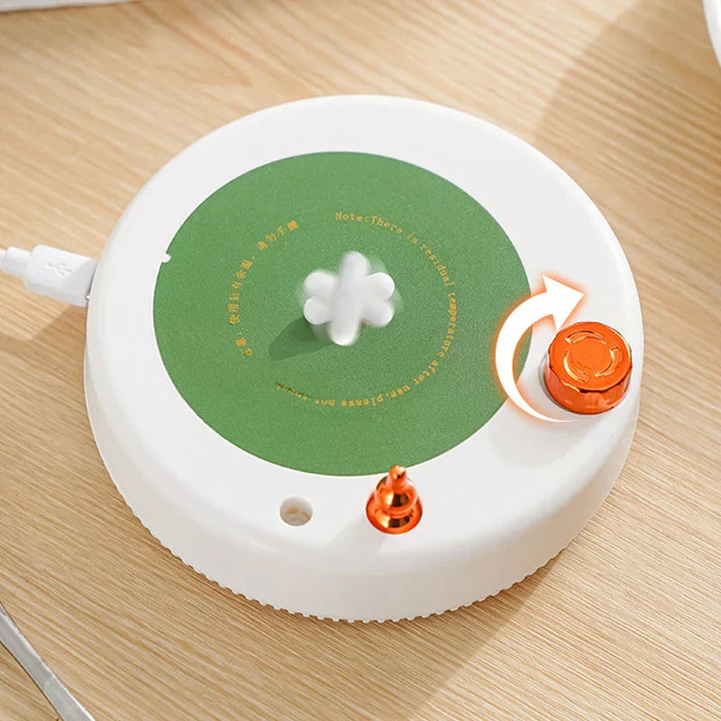 Insulated Mug - Close up of a white USB mug warmer showing its green heating pad, adjustment knob, and power input