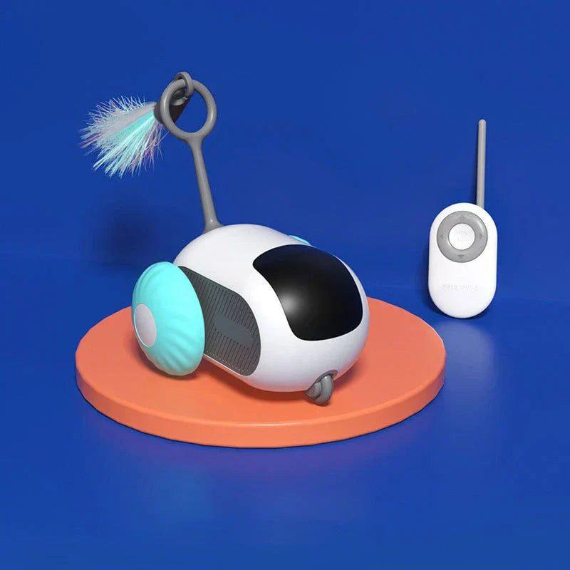 Coche de juguete electrónico para perseguir gatos: juguete robótico para gato blanco y negro con rueda azul claro junto a un control remoto a juego, sobre base circular naranja