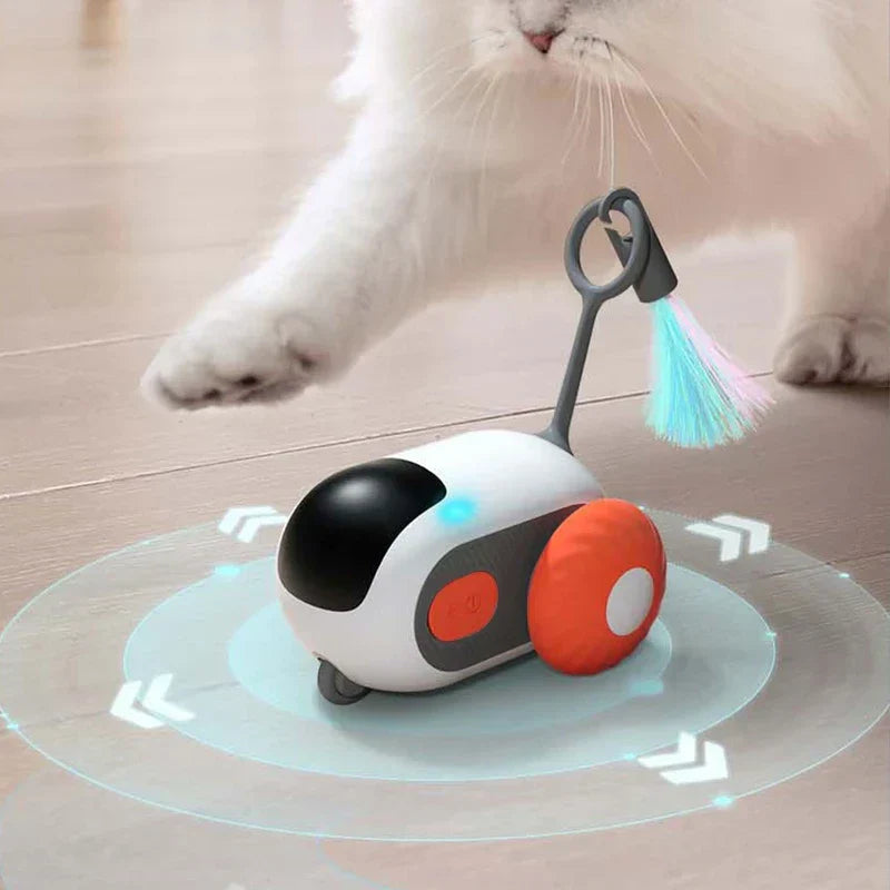 Electronic Cat Chase Toy Car - White cat reaching a paw toward an orange-wheeled remote cat toy with a glowing blue light and feather teaser