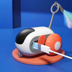 Coche de juguete electrónico para perseguir gatos: juguete robótico para gato con manchas blancas y negras, rueda naranja, cable de carga conectado, accesorio de cola de plumas, sobre base circular naranja