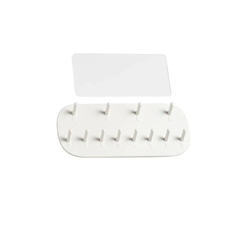 Jewelry Storage - Adhesive mounting pad and white 12-peg organizer base laid flat against a white background