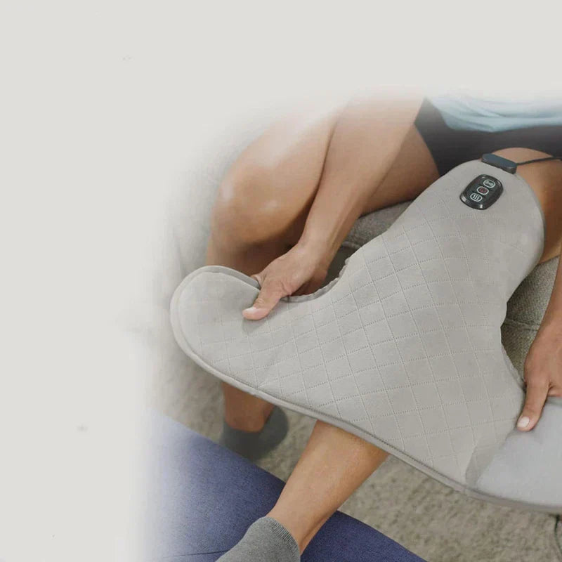 Knee Compression Sleeve - A person holds a light gray quilted knee massager resting on their knee
