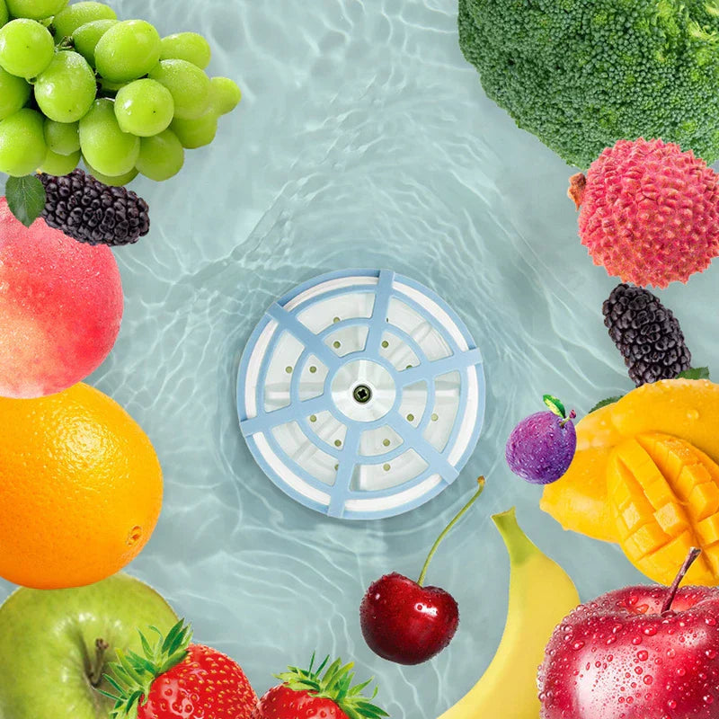 Mini Dishwasher - A light blue and white circular puck sits in rippling water, surrounded by fresh fruits and broccoli along the edges