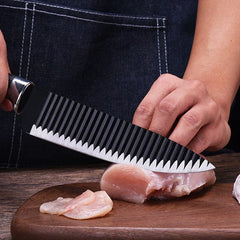 A person holding a ridged kitchen knife slicing raw chicken breast on a wooden cutting board