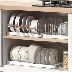 Kitchen Storage Rack - Extendable cabinet pan and dish organizer rack holding upright cookware, plates and pot lids inside a kitchen cabinet shelf