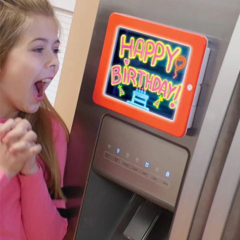 Drawing Board - Orange-framed glow drawing pad mounted on a fridge, screen displays neon 'Happy Birthday!' artwork; girl looks excited beside it
