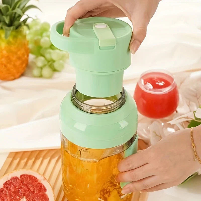 Centrifugal Juicer Machine - Hands attaching light green lid to portable blender jar with orange liquid, half grapefruit and glass of juice nearby