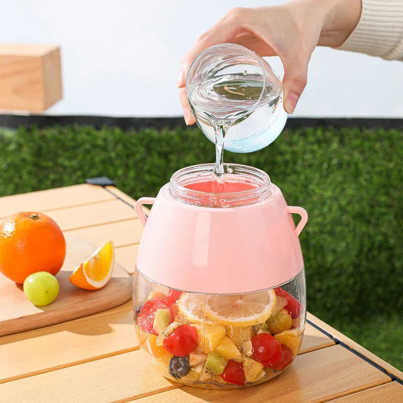 Blender Bottle - Hand pouring water from a small glass into a pink container holding cut fruit, with fruit on a nearby wooden board