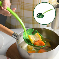 Strainer Spoon - Hand holding green monstera leaf utensil lifting corn and carrot from a small stainless steel saucepan, with inset showing full utensil shape