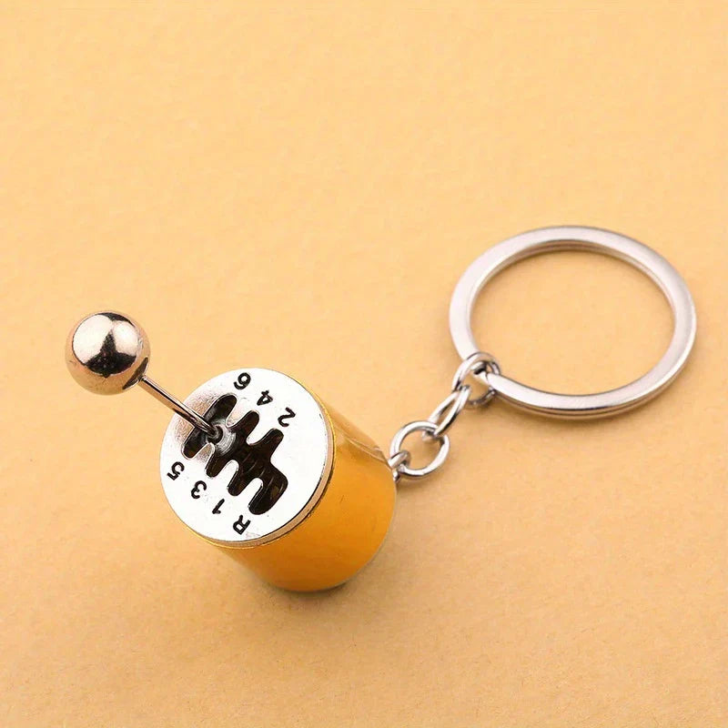 Leather Keychain - Yellow manual car gear shift shaped keychain on a light tan background