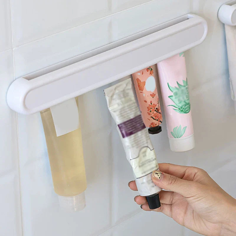 Wall Mount Rack - White wall-mounted organizer holding hanging toiletry tubes, with a hand inserting one tube