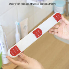 Wall Mount Rack - Hands holding a long white object with three red adhesive patches on its back, over a bathroom counter.