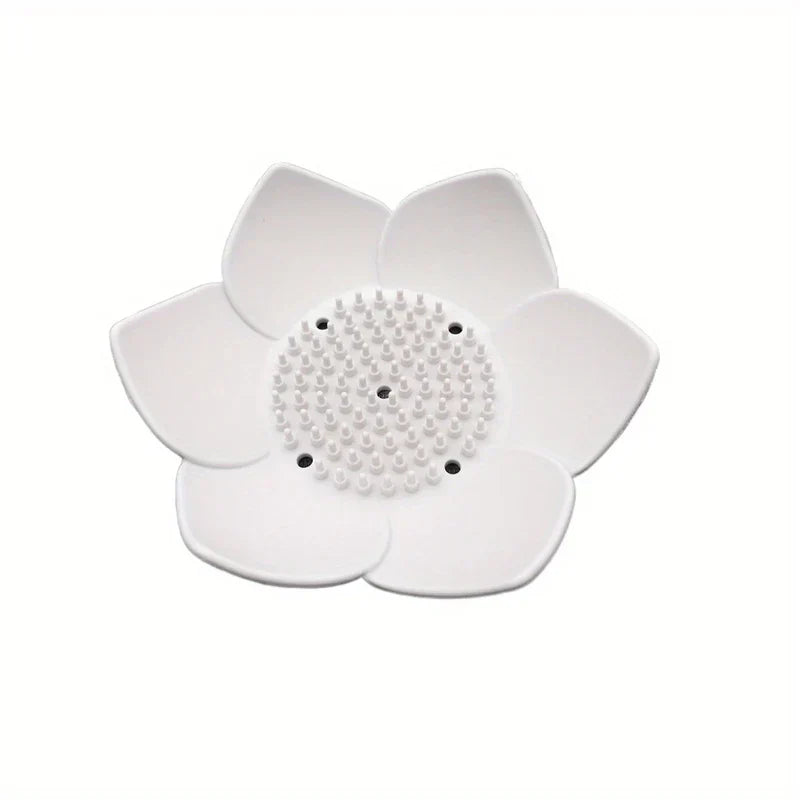 Soap Dish Holder - A white flower-shaped object with raised central bumps and six drainage holes.