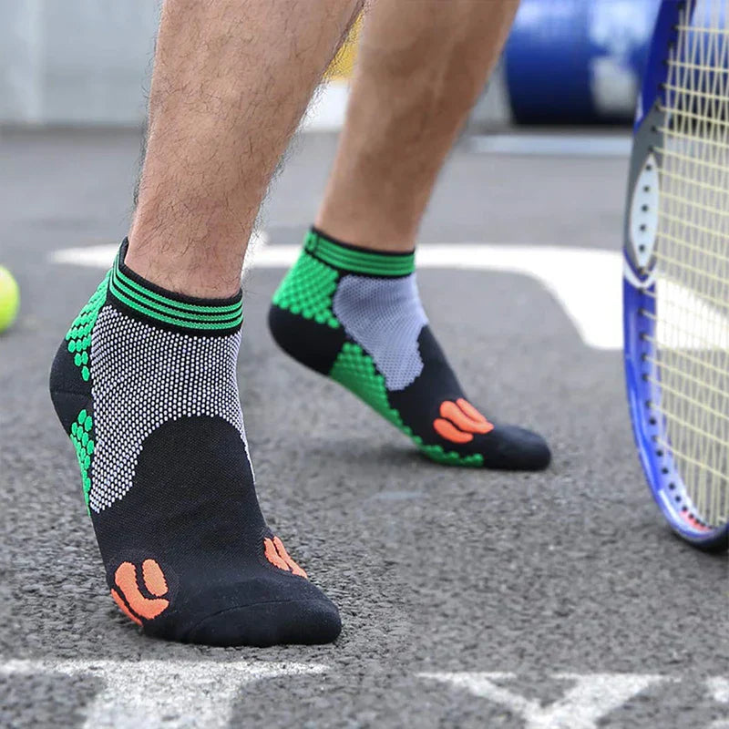 Casual Socks Pack - Person stepping forward on a paved tennis court wearing short athletic socks, showing the inner ankle mesh panel of the sock, with a tennis racket and ball to the side