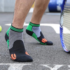 Casual Socks Pack - Person stepping forward on a paved tennis court wearing short athletic socks, showing the inner ankle mesh panel of the sock, with a tennis racket and ball to the side