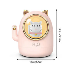 Humidifier Diffuser - Pink cat-shaped humidifier with gold accents, dimension labels showing 13.5cm height and 12cm width, front face has a waving cat illustration and H2O marking.