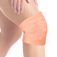 Knee Brace Compression Sleeve - Close-up of a person’s knee, wearing a peach silicone magnetic knee brace, with a hand resting on their thigh