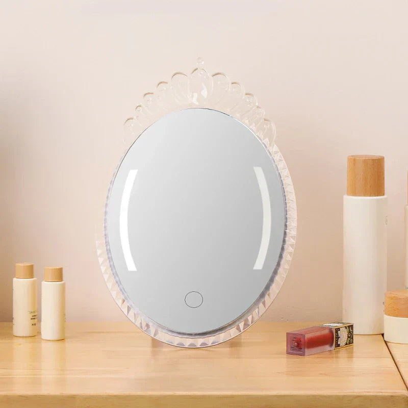 Led Makeup Mirror - Freestanding mirror placed on light wood vanity surface surrounded by skincare bottles and lip product