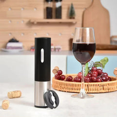 Manual Beer Bottle Cap Opener Tool - Electric wine opener on a kitchen counter beside a wine glass, red grapes, corks, and a foil cutter