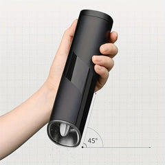 Coffee Bean Grinder - Hand holding the black grinder tilted at a 45-degree angle, demonstrating recommended operating position