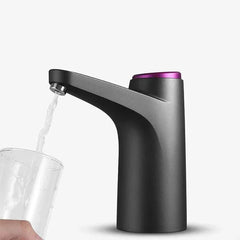 Water Pump Dispenser - Dark gray dispenser with purple accent dispensing water into a held clear glass