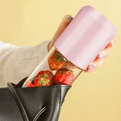 Hand holding pink personal blender placing into small handbag compact travel size