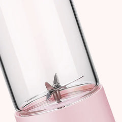 Close-up of stainless steel 6-blade assembly inside pink portable blender glass jar