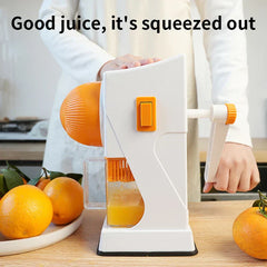 Fruit Juicer - Person operating the hand crank juicer on a wood counter, with plates of fresh oranges placed on either side of the unit