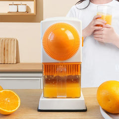 Fruit Juicer - Manual citrus juicer on a wooden counter with halved and whole oranges, person holding orange juice glass behind it.