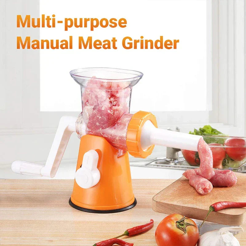 Mincer - Orange and white multi-purpose manual meat grinder with meat exiting onto a wood cutting board, surrounded by fresh vegetables